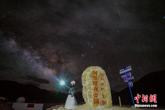 圖為6月20日晚，游客“打卡”西藏阿里暗夜公園，天上是銀河與流星（右上角）。曹枝清 攝