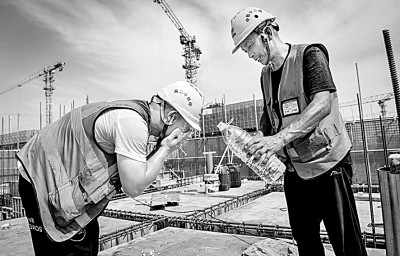 近日，多地迎來高溫天氣，圖為中鐵十二局工人在河北雄安新區(qū)大河片區(qū)安置房項目建設現場洗臉解暑。 新華社發(fā)